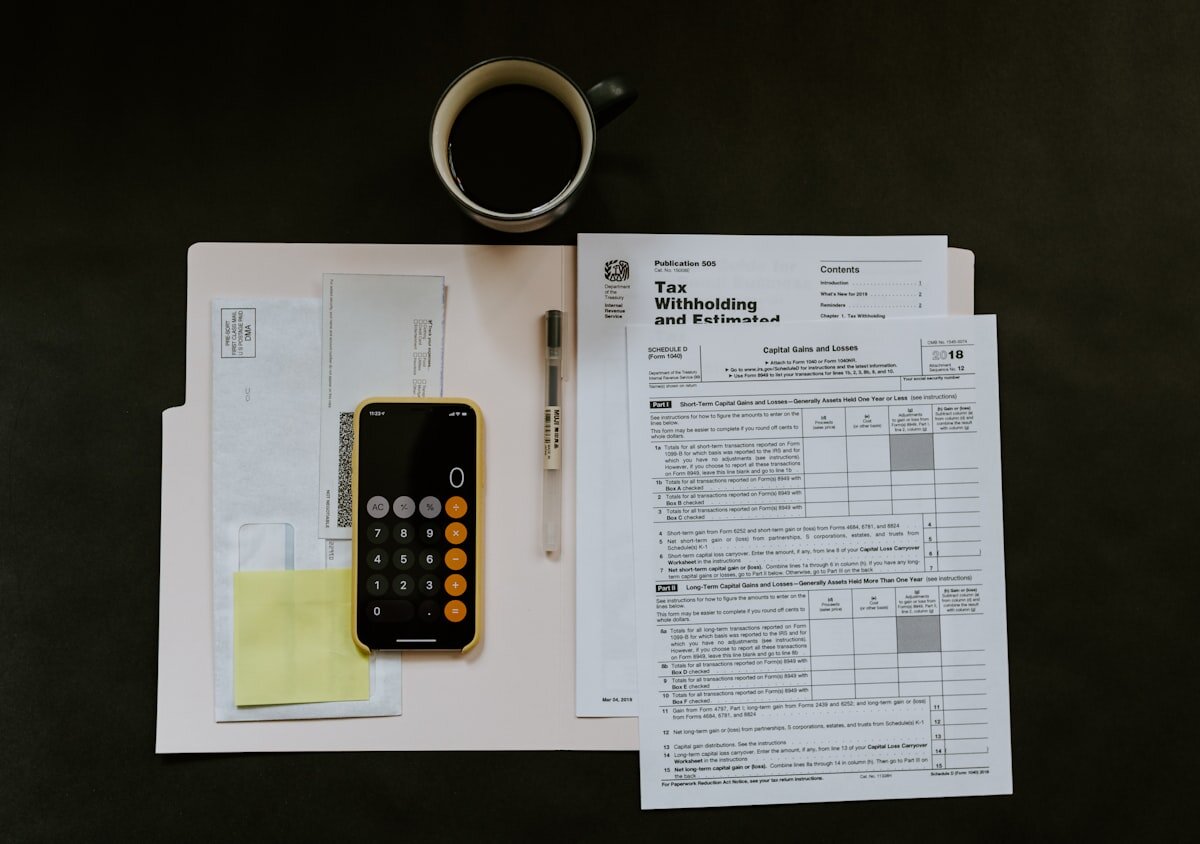 Documentos legales, calculadora y pluma sobre una mesa, simbolizando asuntos financieros